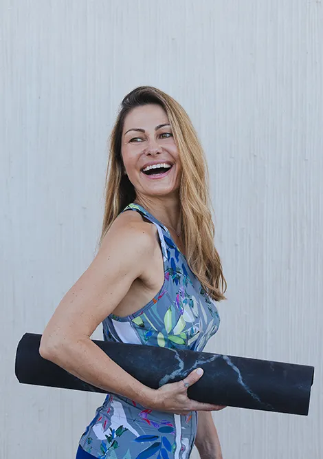 Anja mit aufgerollter Yoga-Matte in der Hand